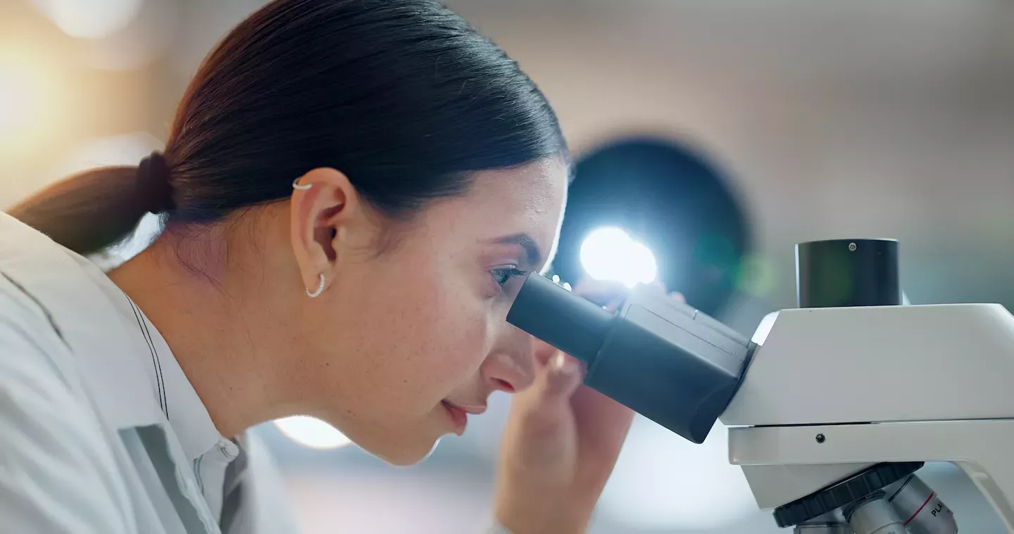 Person looking through microscope Person looking through microscope