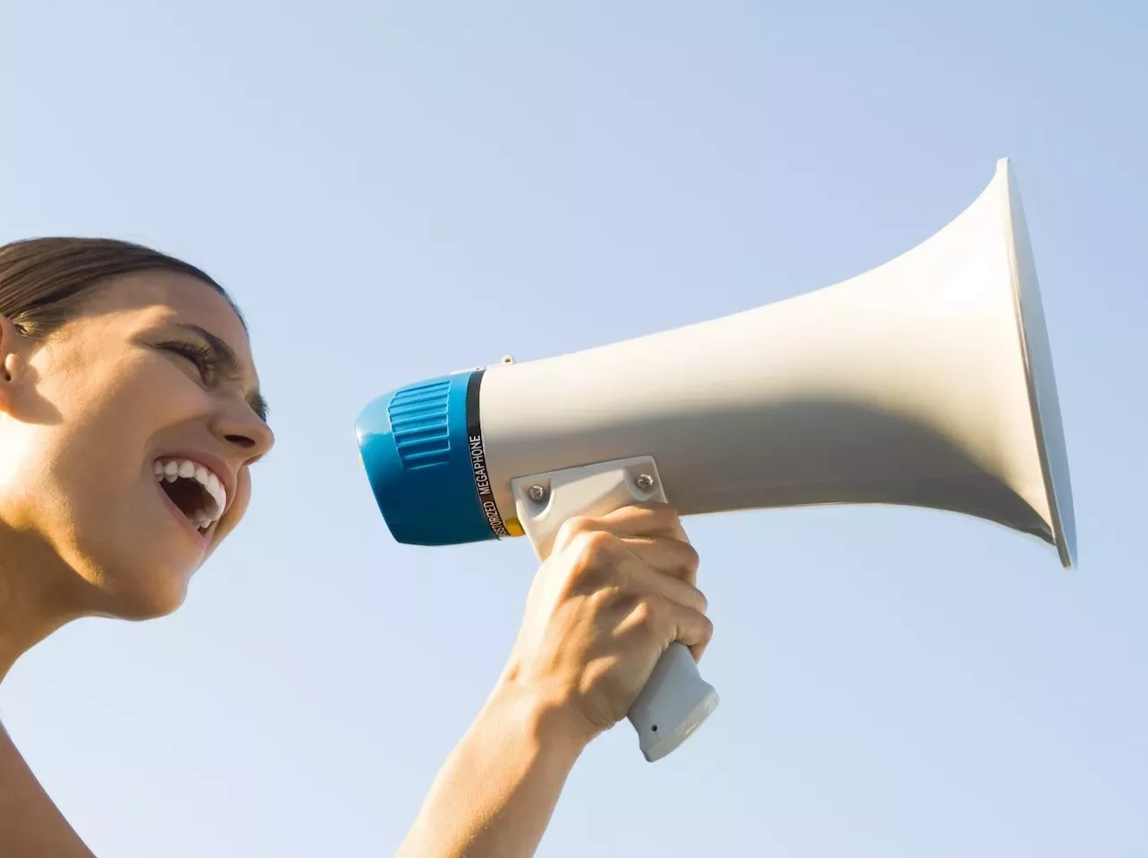person speaking through megaphone person speaking through megaphone